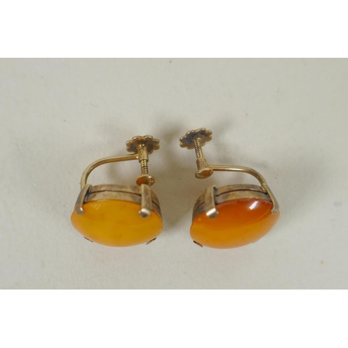 634 - A vintage graduated butterscotch amber necklace and a pair of matching earrings with silver gilt mou... 