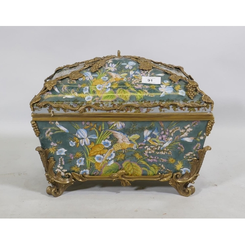 91 - A porcelain casket decorated with exotic birds and brass mounts with grape and vine detail, 37 x 27 ... 