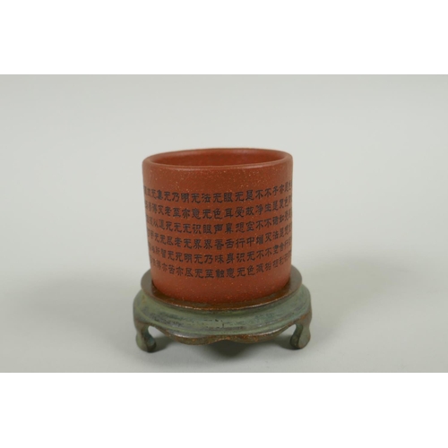 95 - A Chinese YiXing cylinder cup on a bronze stand, decorated with allover character inscription, 6cm d... 