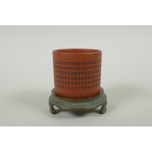 95 - A Chinese YiXing cylinder cup on a bronze stand, decorated with allover character inscription, 6cm d... 