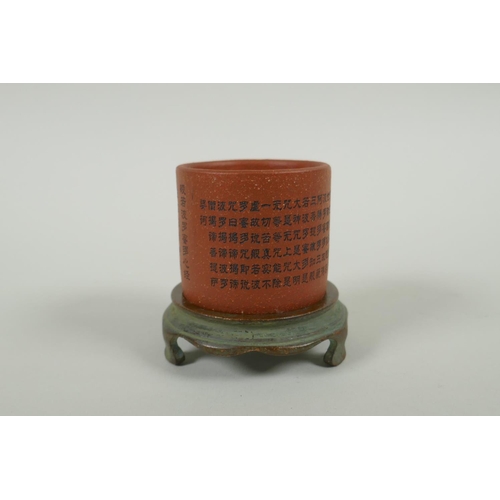 95 - A Chinese YiXing cylinder cup on a bronze stand, decorated with allover character inscription, 6cm d... 