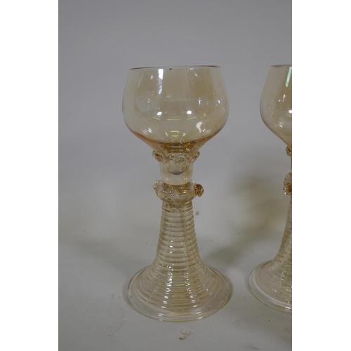 322 - A set of seven C19th amber coloured Hock wine glasses, and five more similar with etched grape and v... 