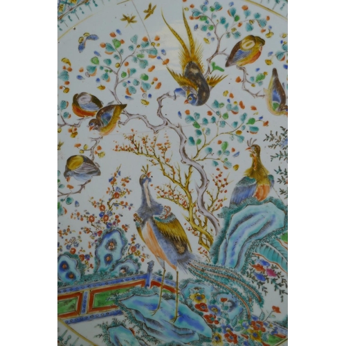 334 - An C18th/C19th Chinese famille verte porcelain charger decorated with peacocks and asiatic birds per... 