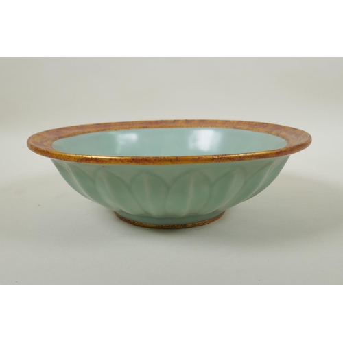 100 - A Chinese celadon glazed porcelain flower shaped bowl with gilt metal rim and foot, underglaze carp ... 