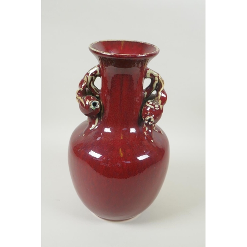 103 - A Chinese flambe glazed pottery vase, the two handles in the form of pomegranates, 30cm high