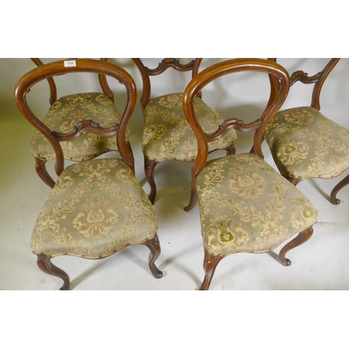 1094 - A set of five Victorian walnut balloon back dining chairs with carved backs, raised on cabriole supp... 