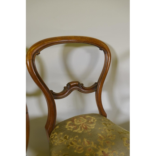 1094 - A set of five Victorian walnut balloon back dining chairs with carved backs, raised on cabriole supp... 