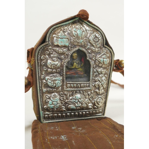 110 - A Tibetan gau box in a silk carry bag, 10 x 13cm