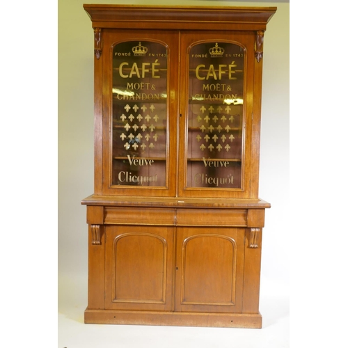 1102 - A Victorian mahogany library bookcase, the upper section with two glazed doors and eglomise style de... 