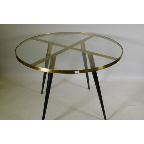 1113 - A Swoon 'Eros' polished brass four seater dining table with glass top, 110cm diameter, 75cm high