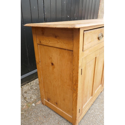 1121 - An early C19th stripped pine dresser base, three drawers over two cupboards flanking a dog kennel, r... 