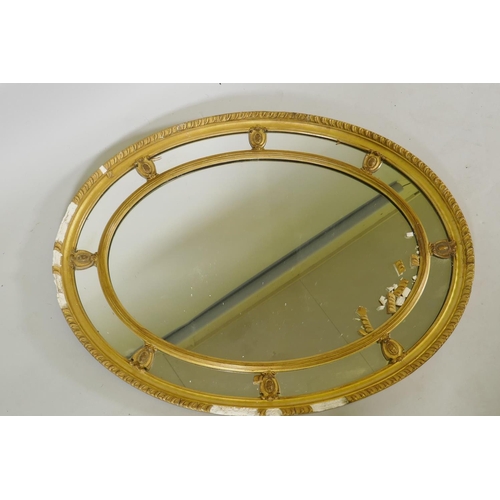 1129 - An early C20th oval sectional giltwood and plaster wall mirror, AF, 87 x 67cm