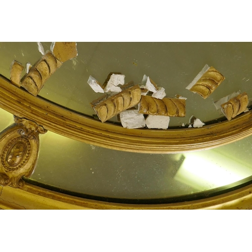 1129 - An early C20th oval sectional giltwood and plaster wall mirror, AF, 87 x 67cm