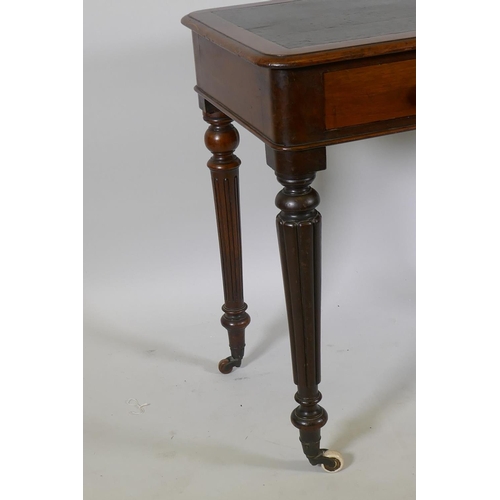 1130 - An early C19th mahogany two drawer writing table with inset faux leather top, raised on reeded suppo... 