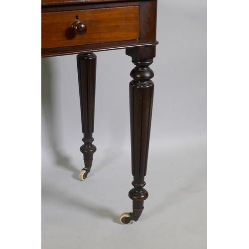 1130 - An early C19th mahogany two drawer writing table with inset faux leather top, raised on reeded suppo... 