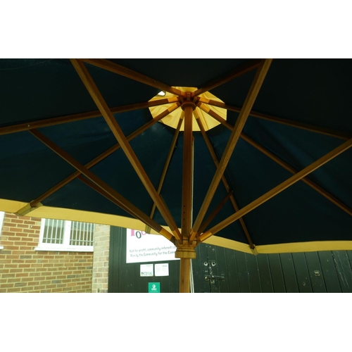 1136 - A canvas folding garden parasol with stand, 270cm high