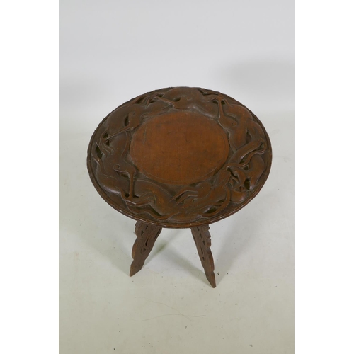 1143 - A C19th colonial carved hardwood occasional table with dragon decoration, 51cm high x 51cm diameter