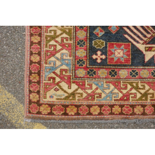 1150 - A blue ground wool Kazak carpet decorated with three medallions, with pink and cream borders, 172 x ... 