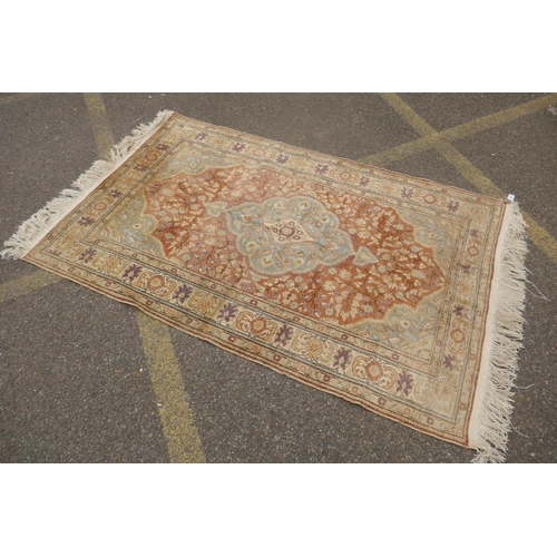 1157 - A Turkish faded silk rug with blue central medallion on a coral field, 120 x 184cm