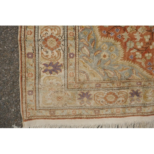 1157 - A Turkish faded silk rug with blue central medallion on a coral field, 120 x 184cm