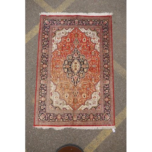 1161 - A Persian terracotta ground silk Heriz rug with black borders, 102 x 148cm