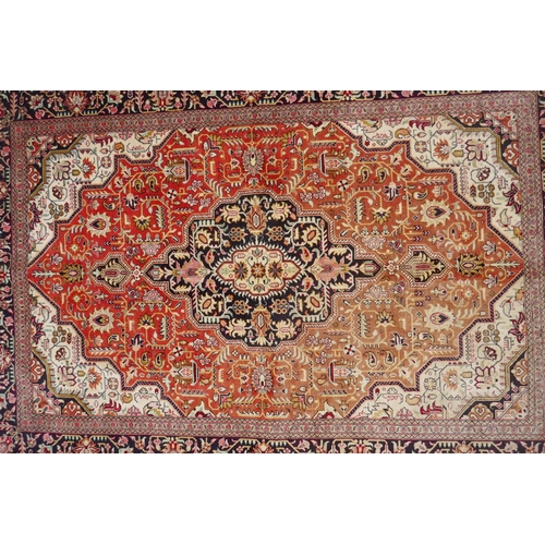 1161 - A Persian terracotta ground silk Heriz rug with black borders, 102 x 148cm