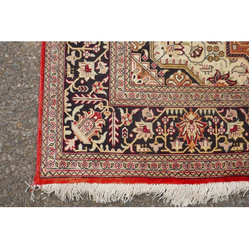 1161 - A Persian terracotta ground silk Heriz rug with black borders, 102 x 148cm