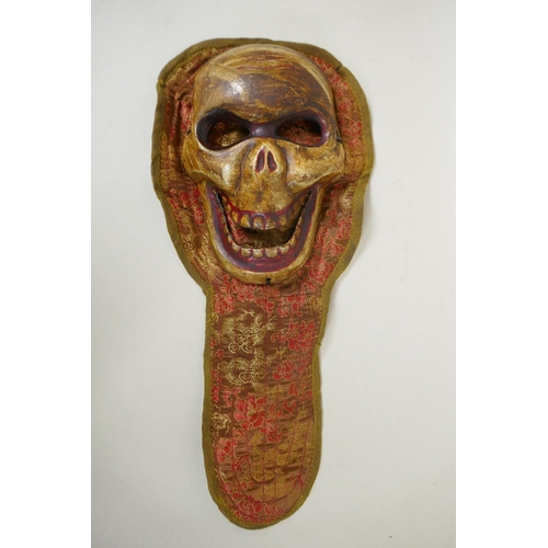 119 - A Tibetan ceramic Citipati death mask on a silk mount, 45cm long