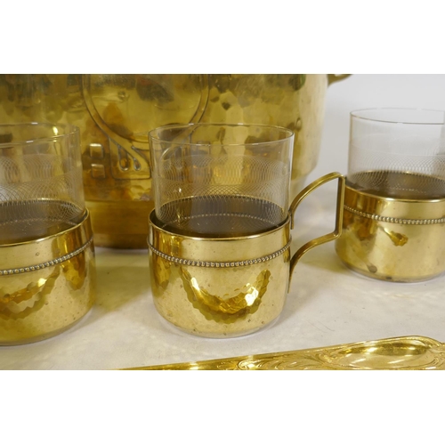 122 - A WMF Art Nouveau/Jugendstil hammered brass punch bowl and six glass holders, lacks one glass, and a... 