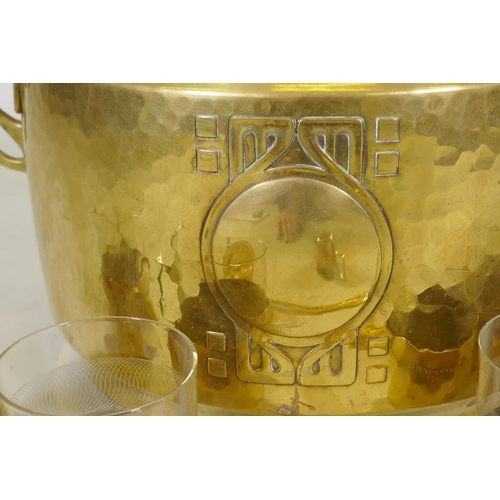 122 - A WMF Art Nouveau/Jugendstil hammered brass punch bowl and six glass holders, lacks one glass, and a... 