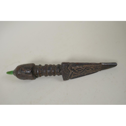 125 - A Tibetan carved hardwood ceremonial phurba with a metal tip and inset green jade stone, 22cm