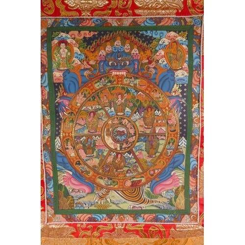 138 - A Tibetan painted thangka depicting the Buddhist wheel of life, in a silk mount, 56 x 81cm