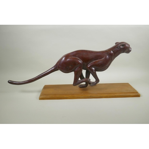 16 - A bronzed white metal figure of a running jaguar, mounted on a wood base, 68cm long