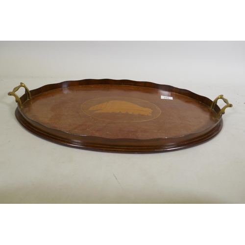 172 - An Edwardian mahogany oval serving tray with shaped gallery, brass handles and shell inlaid decorati... 