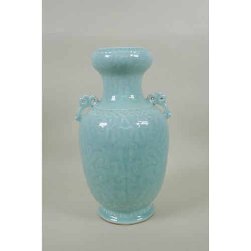 173 - A Chinese celadon glazed porcelain two handled vase with archaic style underglaze dragon decoration,... 