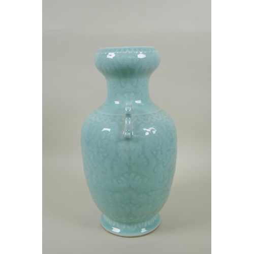 173 - A Chinese celadon glazed porcelain two handled vase with archaic style underglaze dragon decoration,... 