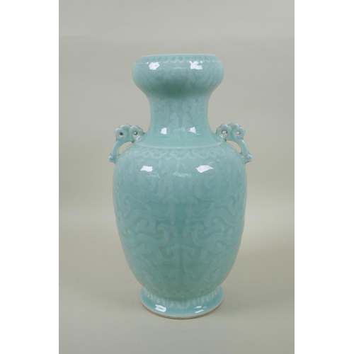 173 - A Chinese celadon glazed porcelain two handled vase with archaic style underglaze dragon decoration,... 