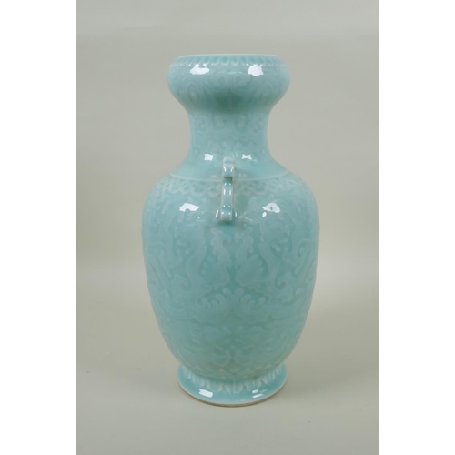 173 - A Chinese celadon glazed porcelain two handled vase with archaic style underglaze dragon decoration,... 