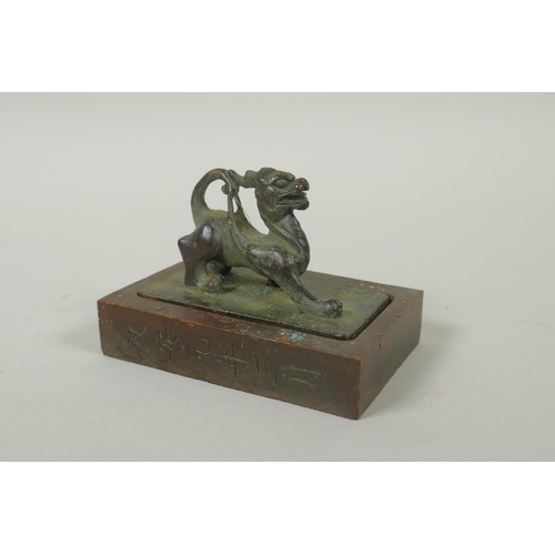 175 - A Chinese bronze two part seal with dragon knop and character inscriptions, 8 x 6cm