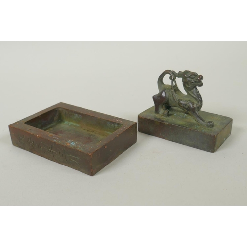 175 - A Chinese bronze two part seal with dragon knop and character inscriptions, 8 x 6cm