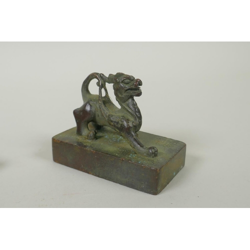 175 - A Chinese bronze two part seal with dragon knop and character inscriptions, 8 x 6cm