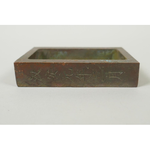 175 - A Chinese bronze two part seal with dragon knop and character inscriptions, 8 x 6cm