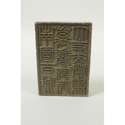 175 - A Chinese bronze two part seal with dragon knop and character inscriptions, 8 x 6cm