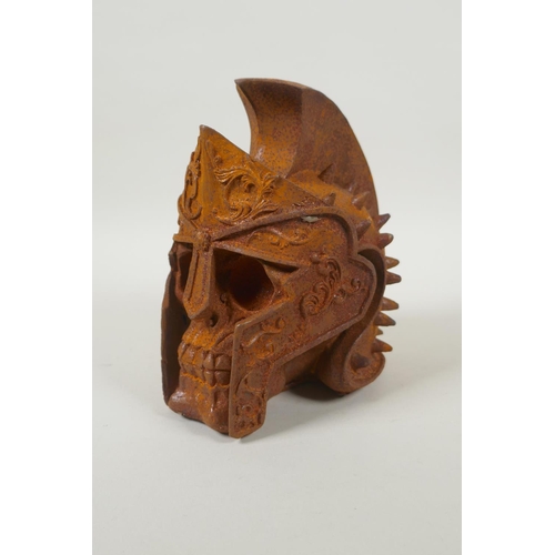 177 - A decorative cast iron skull wearing a Roman helmet, 17cm high