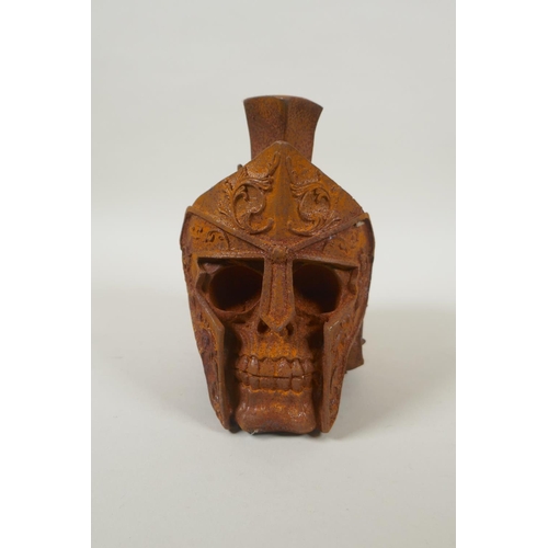 177 - A decorative cast iron skull wearing a Roman helmet, 17cm high