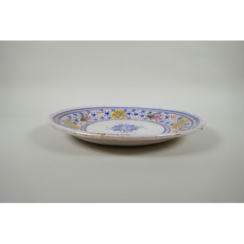 210 - An antique Delft plate decorated with a floral design, 32cm diameter