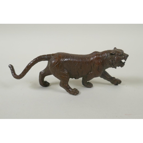 211 - An Oriental cast bronze figure of a tiger, indistinct impressed mark to base, 15cm long