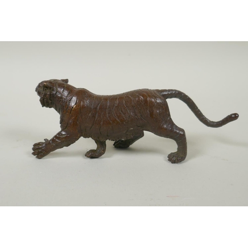 211 - An Oriental cast bronze figure of a tiger, indistinct impressed mark to base, 15cm long