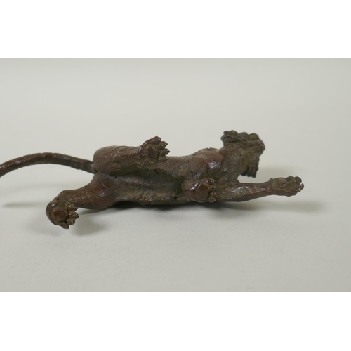 211 - An Oriental cast bronze figure of a tiger, indistinct impressed mark to base, 15cm long