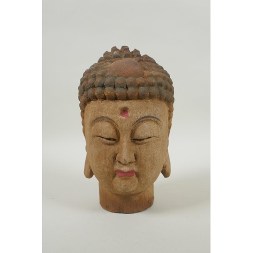 213 - A Chinese carved, painted and distressed wood Buddha head, 21cm high